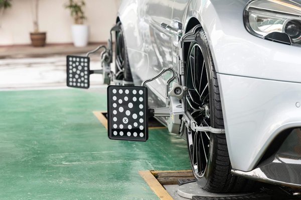 What are the symptoms of faulty wheel alignment and how can it be corrected?